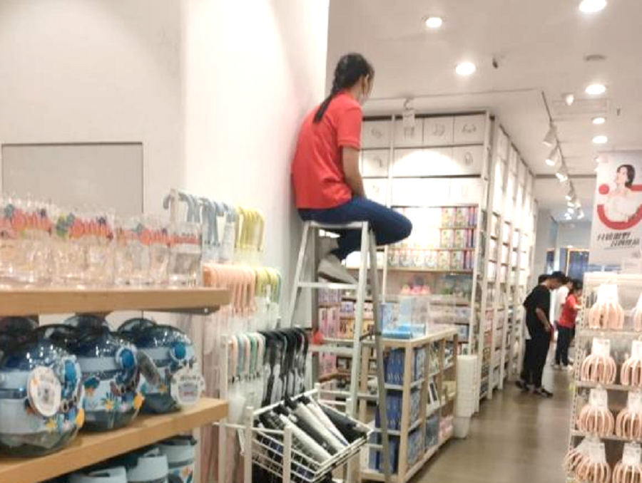 名创优品特色防盗，店员坐上梯子